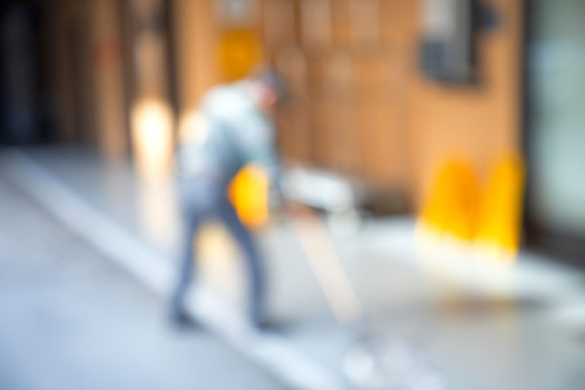 Asian old man janitor mopping floor in the building corridor with cleaning tool, among sunlight in the morning, blur image use as a background.